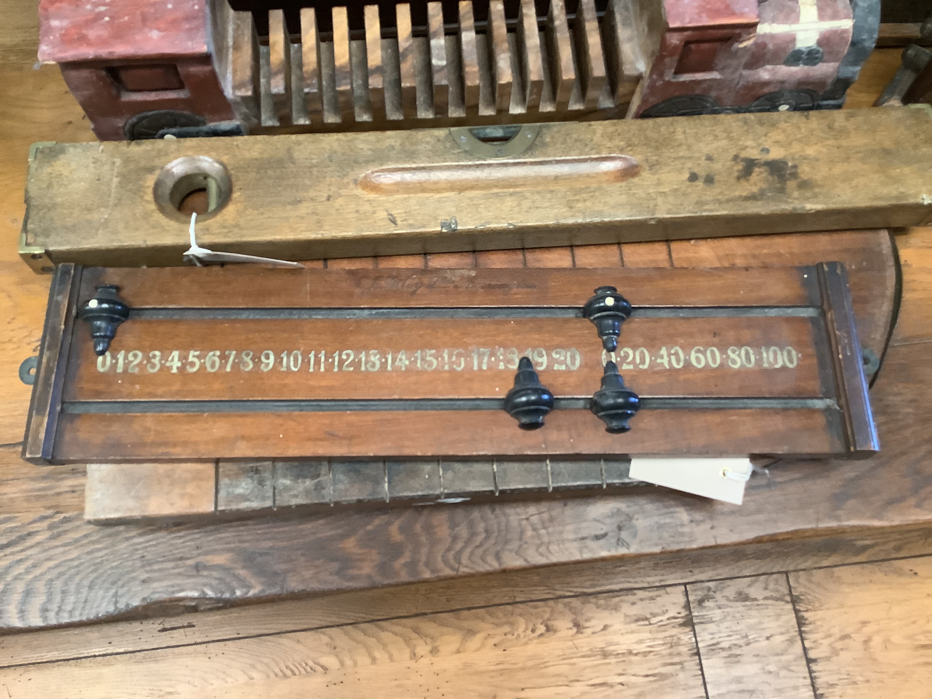 A Shove Ha'penny board, a Preston & Sons brass-mounted spirit level, a Riley's billiards scoreboard and a tea caddy